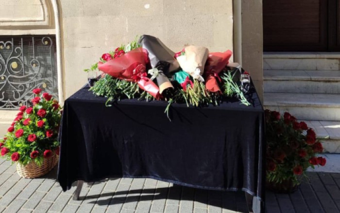 Жители Баку несут цветы к посольству Ирана